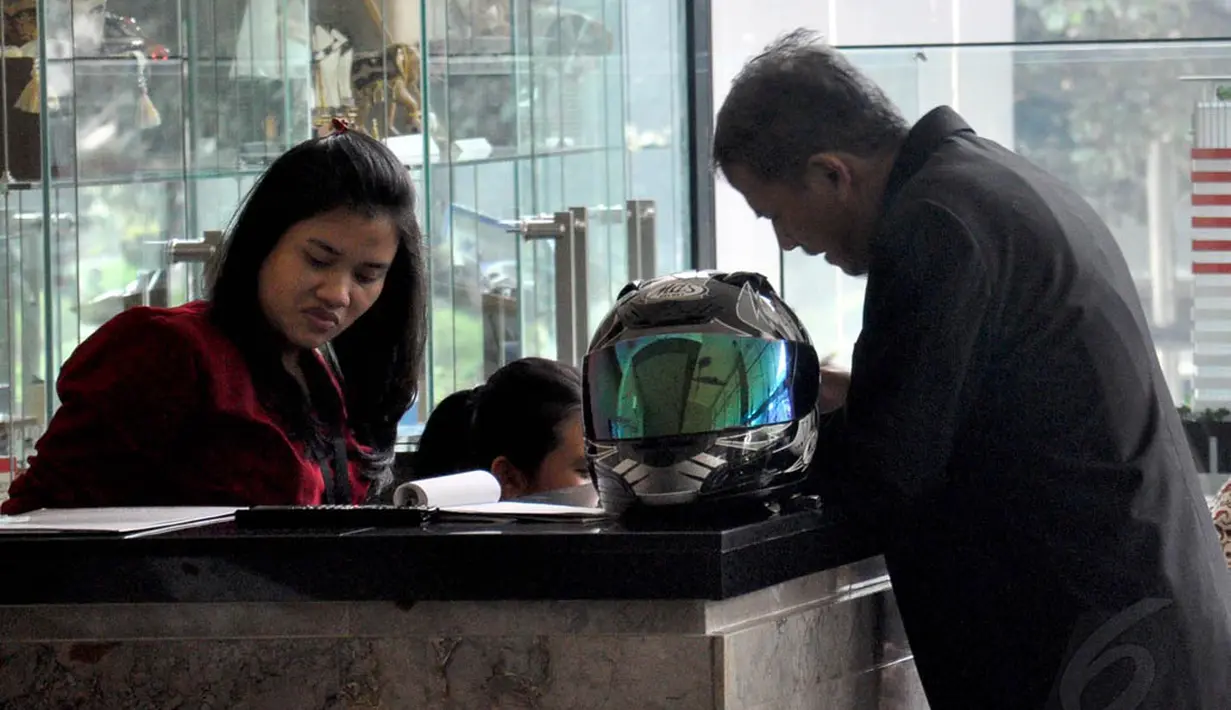 Mengenakan jaket hitam, Anggito Abimanyu tampak membawa masuk helm yang dibawanya ke dalam lobi KPK, Jakarta, (7/9/14). (Liputan6.com/Miftahul Hayat)