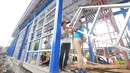 Pekerja tengah menyelesaikan pembangunan halte Trans Jakarta untuk Jalan layang Ciledug - Tendean di Jakarta, Senin (26/12). Pembangunan halte ini meleset dari target. (Liputan6.com/Angga Yuniar)