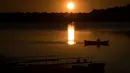 Seorang pria memancing ikan saat matahari terbenam, di danau Lusiai dekat kota kecil Ignalina, sekitar 120 km (74,5 mil) di utara ibukota Vilnius, Lithuania  (3/6/2019). (AP Photo/Mindaugas Kulbis)