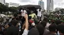 Polisi dan tentara menjaga masyarakat Papua yang memperingati Operasi Trikora 19 Desember 1961 di Patung Kuda, Jakarta, Sabtu (19/12/2020). Salah satu tuntutan massa adalah penghentian segala bentuk diskriminasi dan intimidasi terhadap mahasiswa Papua Barat. (Liputan6.com/Johan Tallo)