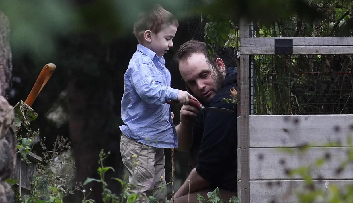 Joshua Boyle bersama anaknya Jonah bermain di kebun di rumah orang tuanya di Smiths Falls, Ontario (14/10). Boyle disandera selama lima tahun bersama istrinya dan ketiga anaknya di Afghanistan. (Lars Hagberg/The Canadian Press via AP)