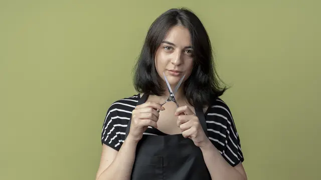 Seorang perempuan memegang gunting untuk memotong rambutnya (Foto Dok: Freepik/stockking)