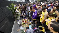 Fans Kobe Bryant berduka saat berkumpul di depan Staples Center, rumah Los Angeles Lakers (26/1/2020). Legenda NBA dan Los Angeles Lakers Kobe Bryant meninggal dunia akibat kecelakaan helikopter di Calabasas, California, Minggu 26 Januari waktu setempat. (AP Photo/Matt Hartman)