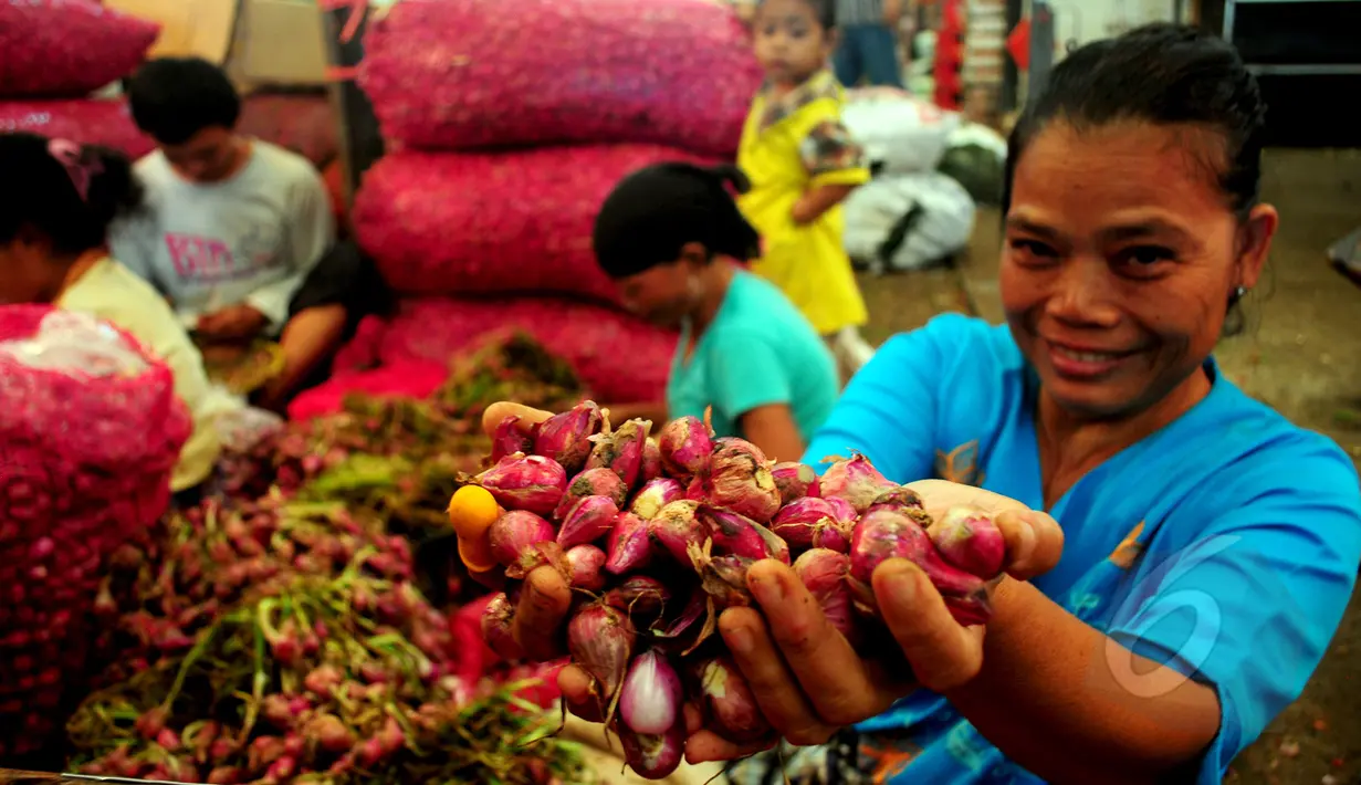 Seorang pedagang menunjukkan bawang merah di Pasar Induk sayur dan buah, Kramat Jati, Jakarta, Jumat, (13/3/2015). Harga bawang merah di sejumlah pasar menembus Rp 30 ribu per kg atau mengalami kenaikan sekitar Rp 2000-5000/kg. (Liputan6.com/Yoppy Renato)