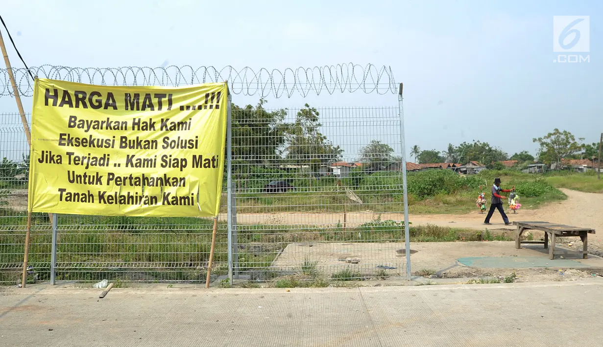 Spanduk pernyataan sikap warga terpasang di lokasi proyek perluasan landasan pacu atau Runway 3A Bandara Soekarno-Hatta, Rawa Rengas, Kosambi, Tangerang, Banten, Selasa (2/7/2019). Sekitar 130 KK masih bertahan di rumahnya karena belum menerima ganti rugi. (merdeka.com/Arie Basuki)
