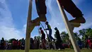 Siswa mengikuti permainan tradisional egrang pada Festival Permainan Tradisional Anak di Desa Wisata Lubok Sukon, Kecamatan Ingin Jaya, Aceh Besar, Aceh, Sabtu (25/7/2026). (AFP/ Chaideer Mahyuddin)