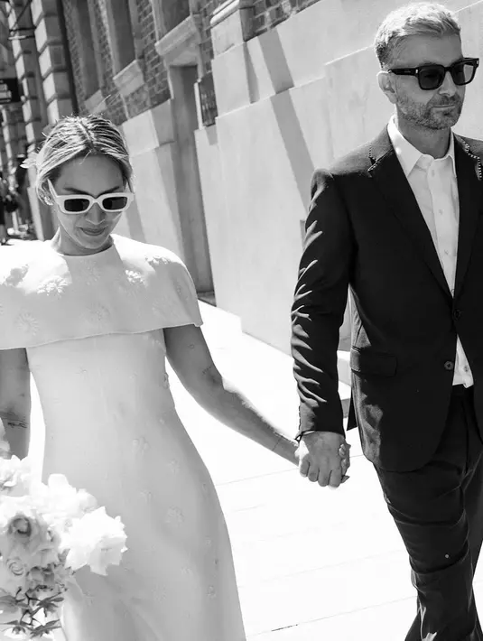 Perempuan berusia 44 tahun ini tampil simpel dalam balutan gaun putih dengan detail cape berwarna putih. [Foto: Instagram/chantaldellaconcetta_]