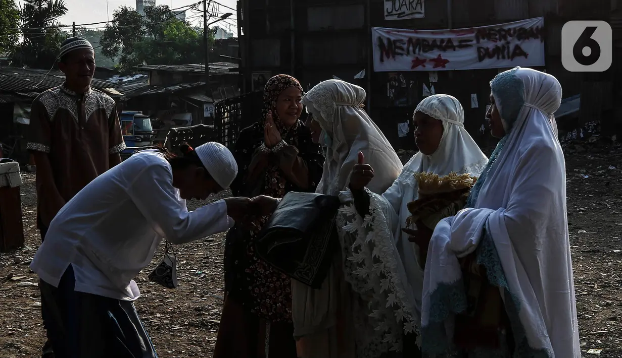 Warga bersalaman saat merayakan Idul Fitri di Pancoran Buntu II, Jakarta Selatan. Kamis (13/5/2021). Mayoritas umat Muslim di Indonesia melaksanakan Sholat Id sesuai dengan ketetapan pemerintah pada Rabu (13/5/2021). (Liputan6.com/Johan Tallo)