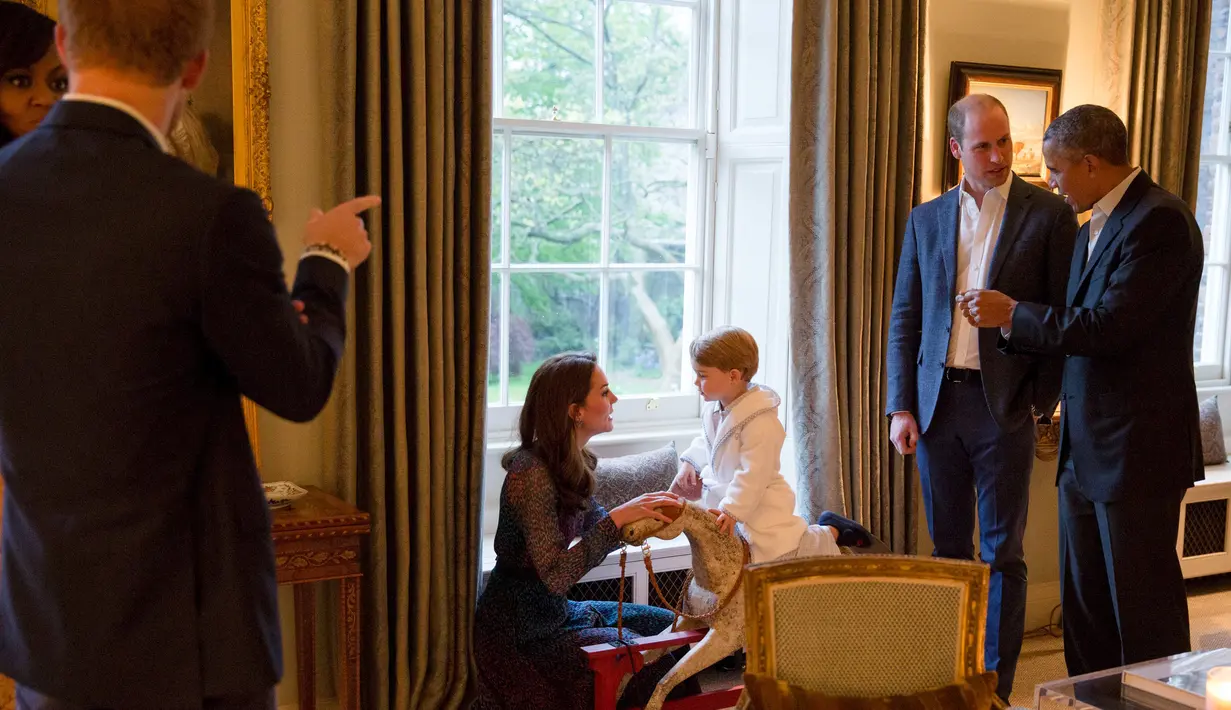 Pangeran William berbincang dengan Presiden AS Barack Obama (kanan) ketika Pangeran George tengah bermain dengan sang ibu, Kate Middleton disela jamuan makan malam di Kensington Palace, London, Jumat (22/4). (Kensington Palace/Pete Souza via Reuters)