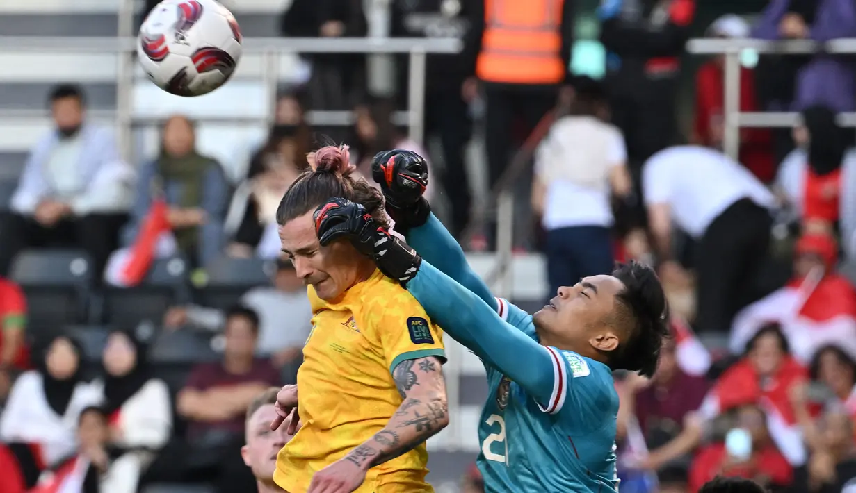 Kiper Timnas Indonesia, Ernando Ari Sutaryadi (kanan) berusaha menghalau bola saat laga 16 besar Piala Asia 2023 melawan Australia yang berlangsung di assim bin Hamad Stadium, Doha, Qatar, Minggu (28/01/2024). (AFP/Hector Retamal)