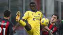 Gelandang Hellas Verona, Destiny Udogie (tengah), berebut bola dengan bek AC Milan, Davide Calabria dalam lanjutan Liga Italia Serie A pekan ke-7 di Stadion San Siro, Milan, Senin (9/11/2020). Hellas Verona bermain imbang 2-2 dengan AC Milan. (AP Photo/Antonio Calanni).