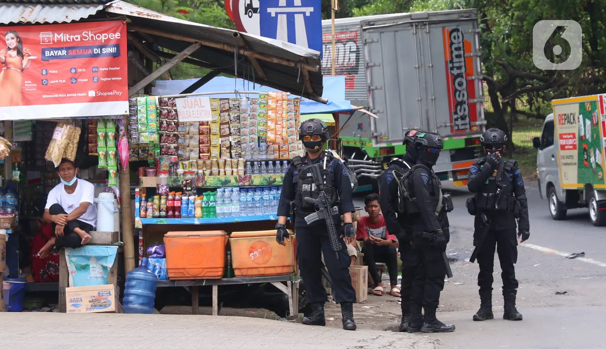Personel Brimob bersenjata melakukan penjagaan ketat di depan pintu masuk Tol Bitung, Tangerang, Baten, Selasa (6/10/2020). Penjagan ketat dilakukan untuk mengamankan dan mencegah aksi buruh yang akan menggelar aksi menolak UU Cipta Kerja. (Liputan6.com/Angga Yuniar)