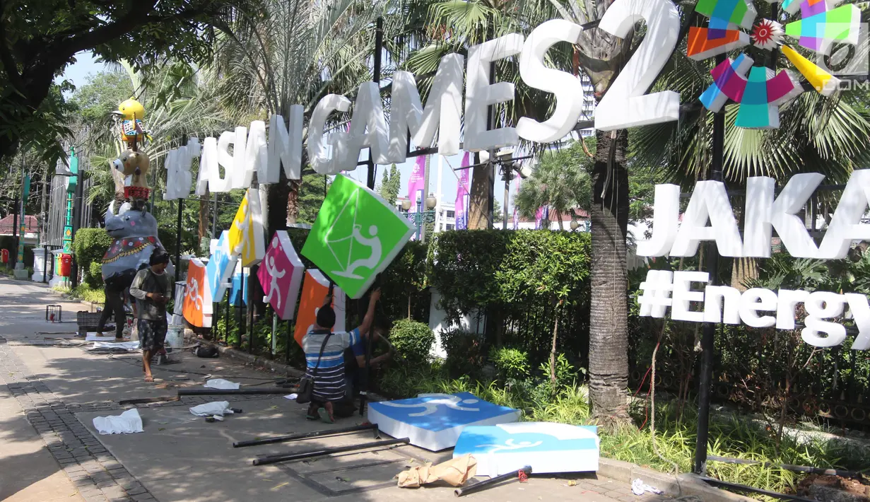 Pekerja memasang neon box Asian Games di depan Balai Kota DKI Jakarta, Jumat (6/7). Pemasangan neon box tersebut untuk mensosialisasikan pelaksanaan Asian Games 2018. (Liputan6.com/Arya Manggala)