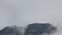Gunung Kinabalu Malaysia terlihat di antara kabut dari pos pemeriksaan gerbang Timpohon sehari setelah gempa di Kundasang, sebuah kota di distrik Ranau pada 6 Juni 2015. (MOHD RASFAN/AFP)