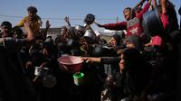 Warga Palestina menunggu bantuan gula dan beras di dapur umum di Khan Younis, Jalur Gaza selatan, Jumat, 31 Oktober 2025. Namun, sering kali, makanan yang tersedia seperti sup, nasi, atau lentil rebus, sangat terbatas dan banyak yang pulang dengan tangan kosong karena kehabisan. (AP Photo/Abdel Kareem Hana)