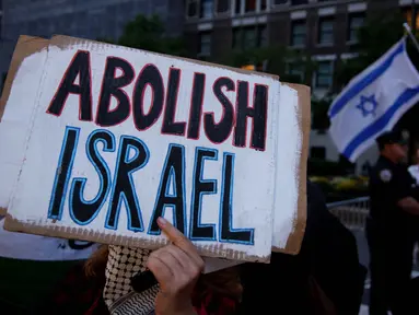 Seorang aktivis pro-Palestina memegang spanduk selama aksi unjuk rasa di luar hotel tempat Perdana Menteri Israel Benjamin Netanyahu berada di New York, Amerika Serikat pada 25 September 2025. (Leonardo MUNOZ/AFP)
