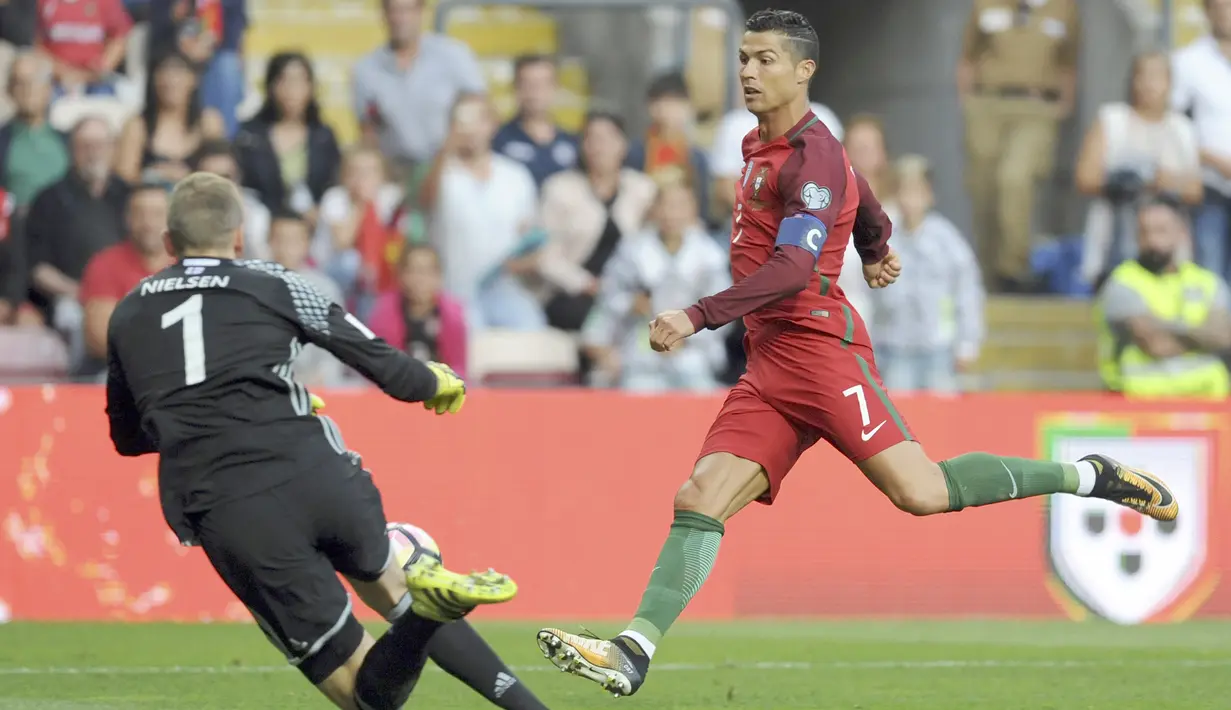 Cristiano Ronaldo berusaha mengecoh kiper Kepulauan Faroe, Gunnar Nielsen pada laga Grup B Kualifikasi Piala Dunia 2018 di Bessa Stadium, Porto, (31/8/2017). Portugal menang 5-1. (AP/Paulo Duarte)