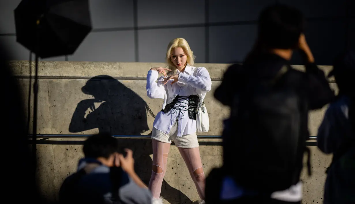 Model Korea Selatan Kim See-hwa (belakang C) berpose saat fotografer mengambil foto selama  Seoul Fashion Week Spring/Summer 2023 di Dongdaemun Design Plaza di Seoul pada 12 Oktober 2022. (AFP/Anthony Wallace)