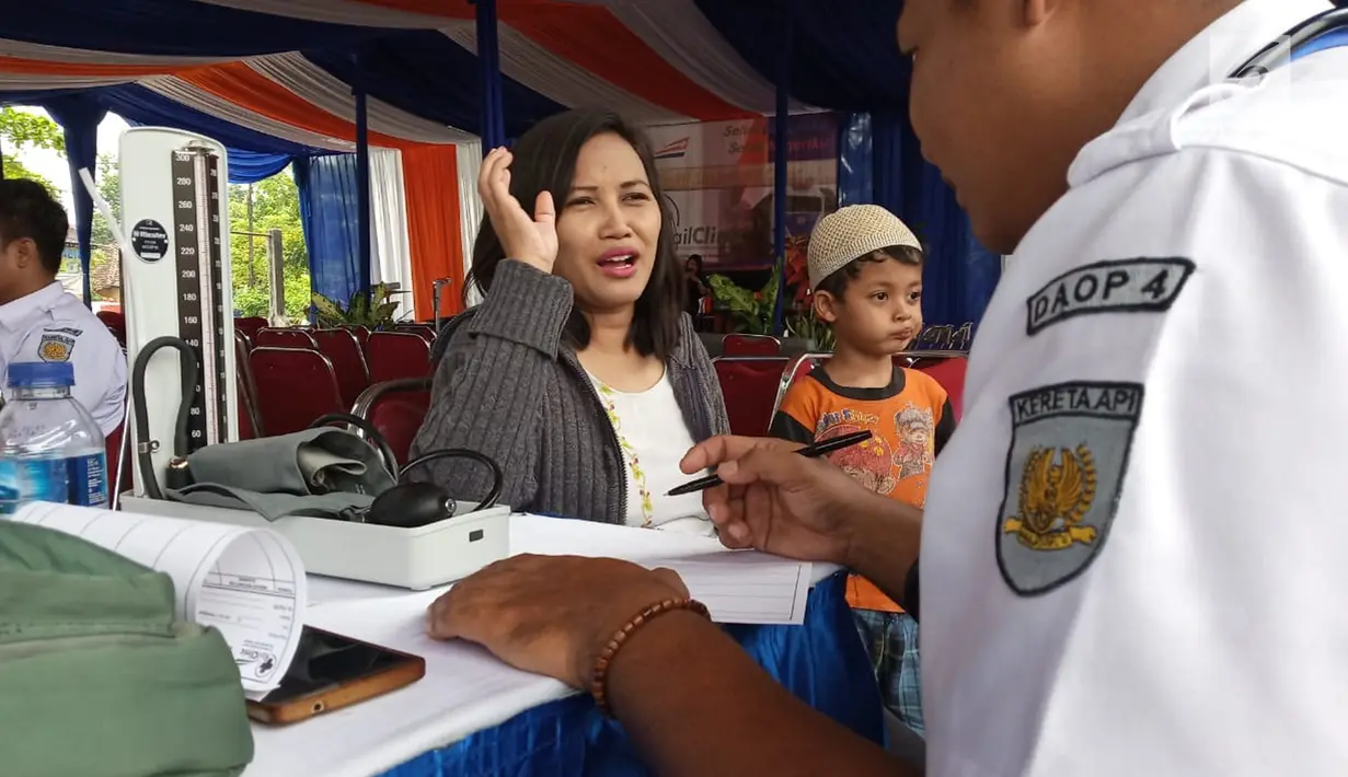 Petugas berbincang dengan pasien yang berobat ke Rail Clinic saat berhenti di Stasiun Alastua, Semarang, Jawa Tengah, Kamis ( 28/3). Pengobatan gratis dari PT KAI ini dihadiri oleh ratusan warga sekitar stasiun. (Liputan6.com/Gholib)