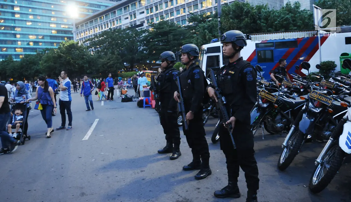 Personel Brimob berjaga di kawasan Bundaran Hotel Indonesia jelang malam pergantian tahun, Minggu (31/12). 20.000 tim gabungan dari TNI dan Polri dikerahkan untuk mengamankan malam tahun baru 2018 di Jakarta. (Liputan6.com/Helmi Fithriansyah)
