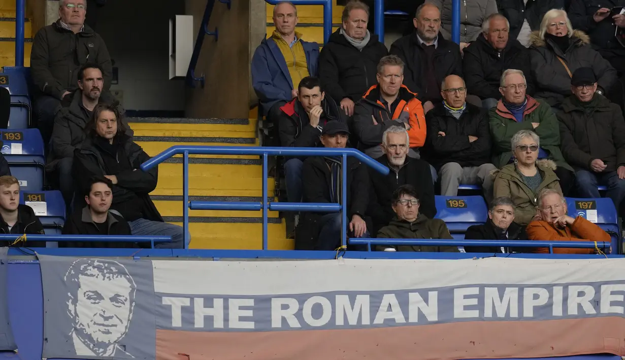 Atas dasar itu semua lah mengapa klub mempertahankan spanduk dengan gambar Abramovich bertuliskan The Roman Empire berlatar belakang bendera rusia masih berada ditengah lapangan. (AP Photo/Kirsty Wigglesworth)