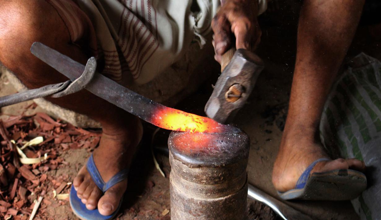 Foto 4 Agustus 2018, perajin membuat pisau tradisional, jambiya, dari sisa-sisa rudal di Hajjah, Yaman. Mereka mengumpulkan serpihan logam sisa-sisa dari rudal yang ditembakkan Koalisi Arab Saudi dan mengubahnya menjadi belati jambiya. (AP/Hammadi Issa)
