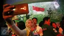 Pengunjung berselfie saat melihat pengibaran bendera Merah Putih di dalam aquarium Ocean Dream Samudra, Ancol, Jakarta (17/8). Taman Impian Jaya Ancol juga mengadakan lomba permainan tradisional, dan panggung hiburan. (Liputan6.com/Immanuel Antonius)
