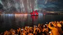 Orang-orang menonton kembang api dan perahu berlayar merah saat White Nights Festival di St.Petersburg, Rusia (24/6). Tradisi ini dimulai di akhir Perang Dunia Kedua untuk memperingati berakhirnya tahun ajaran sekolah. (AP/Dmitri Lovetsky)