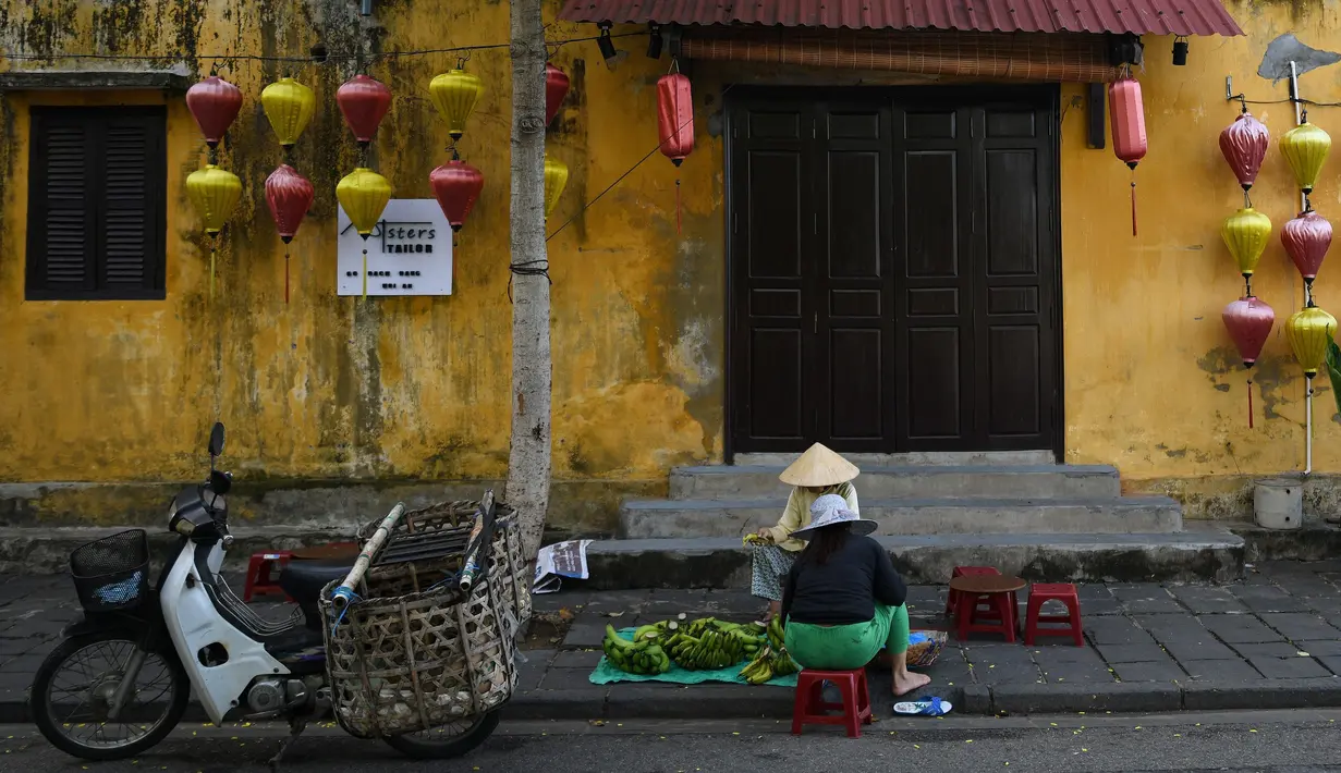 Gambar pada 14 September 2019 memperlihatkan pedagang buah yang ada di kota tua Hoi An, Vietnam. Kota Tua Hoi An merupakan destinasi wisata yang cukup populer di Vietnam, didukung oleh statusnya sebagai salah satu Unesco World Heritage Site. (Manan VATSYAYANA/AFP)