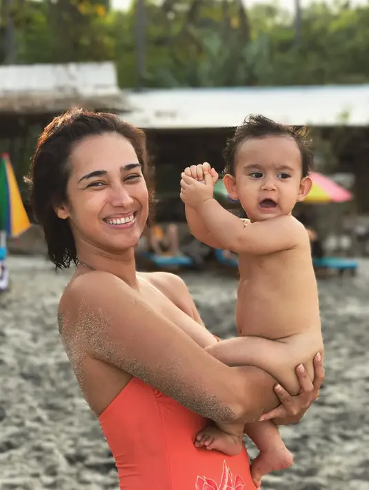 Wisata air sepertinya memang menjadi tempat favorite Alexandra untuk menghabiskan waktu luangnya. Coba lihat, kali ini ia dan sang anak sedang bermain pasirdi pantai. Sweet banget ya? (Instagram/got_alex)