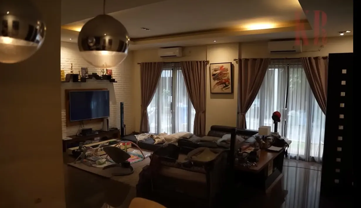 Masuk ke dalam, langsung ruangan tempat sepatu. Dan ada sekat masuk ke living room.  Ruangan tampak luas tidak  banyak sekat dengan gorden warna cokelat. Ello sengaja membuat rumahnya senyaman mungkin karena tidak suka keluar. [Youtube/KR TV]