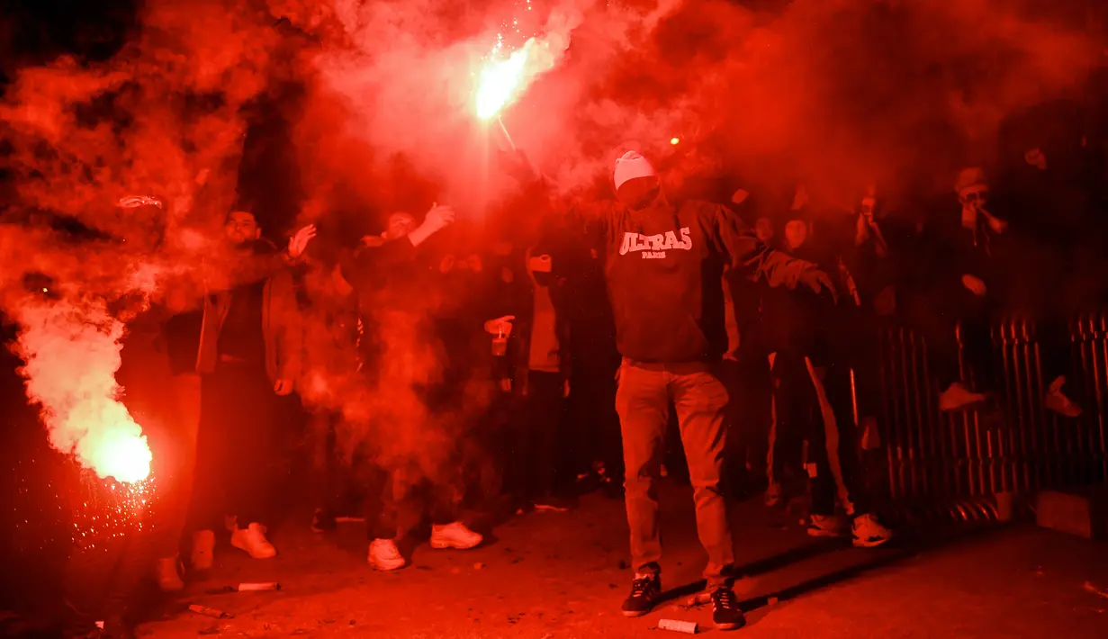 <p>Suporter Paris Saint-Germain (PSG) merayakan gelar Ligue 1 Prancis klub mereka pada akhir laga pekan ke-34 Ligue 1 kontra Lens di luar Parc des Princes, Minggu (24/4/2022) dini hari WIB. PSG juarai Liga Prancis untuk ke-10 kali meski ditahan seri Lens 1-1. (JULIEN DE ROSA / AFP)</p>