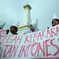 Mahasiswa membawa spanduk saat aksi peringatan Hari Hutan Dunia di Tugu ,Yogyakarta, Senin (21/3). Mahasiswa menuntut pemerintah untuk mencegah kebakaran hutan dan lahan  dan menghukum berat pelakunya. (Foto: Boy Harjanto)