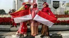 Sejumlah warga berswafoto dengan bendera Merah Putih saat car free day (CFD) di Jakarta, Minggu (13/8/2023). Warga menggunakan kostum unik dan pernak-pernik Merah Putih untuk menyambut Hari Ulang Tahun (HUT) Kemerdekaan ke-78 Republik Indonesia (RI). (Liputan6.com/Faizal Fanani)