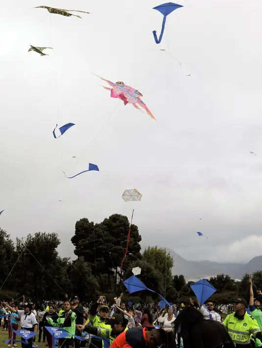 Orang-orang menerbangkan layang-layang selama festival musim panas di taman Simon Bolivar, Bogota, 12 Agustus 2018. Layang-layang beraneka warna dan bentuk menghiasi ibu kota Kolombia tersebut. (AFP PHOTO/John VIZCAINO)