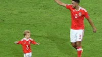 Pemain tim nasional Wales, Neil Taylor, bersama anaknya. (AFP/Denis Charlet)