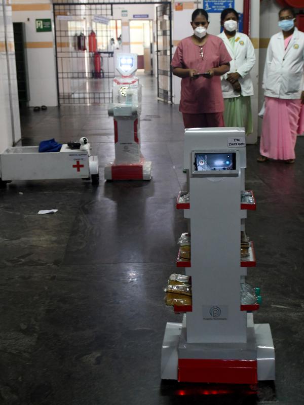 Staf medis berpartisipasi dalam demo robot interaktif 'Zafi' di rumah sakit Stanley Medical di Chennai, 6 April 2020. Rumah sakit ini mengerahkan robot untuk melayani makanan dan obat-obatan bagi pasien Covid-19 dalam upaya meminimalkan tenaga medis tertular virus corona. (Arun SANKAR/AFP)