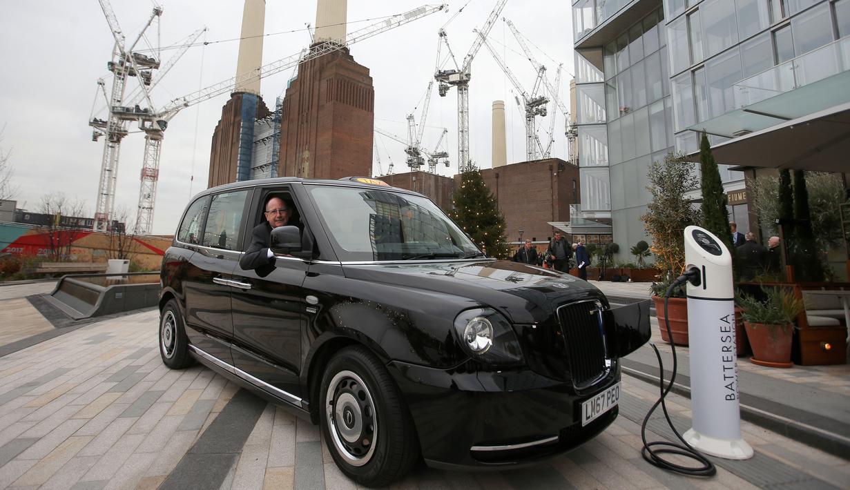 CEO London EV Company, Chris Gubbey duduk di dalam taksi listrik, TX eCity yang sedang mengisi daya listrik di stasiun pengisian elektrik Battersea, London, Selasa (5/12). (AFP PHOTO / Daniel LEAL-OLIVAS)