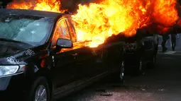 Kondisi Mobil limusin yang dibakar pengunjuk rasa selama protes pelantikan Presiden Donald Trump di Washington, DC, AS, (20/1). Mobil mewah tersebut menjadi bulan-bulanan massa anti-Trump. (Mario Tama/Getty Images/AFP)