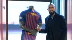Pemain baru Barcelona, Arturo Vidal berpose usai menandatangani jersey dalam presentasi resminya di Stadion Camp Nou, Barcelona, Spanyol, Senin (6/8). (Josep LAGO/AFP)