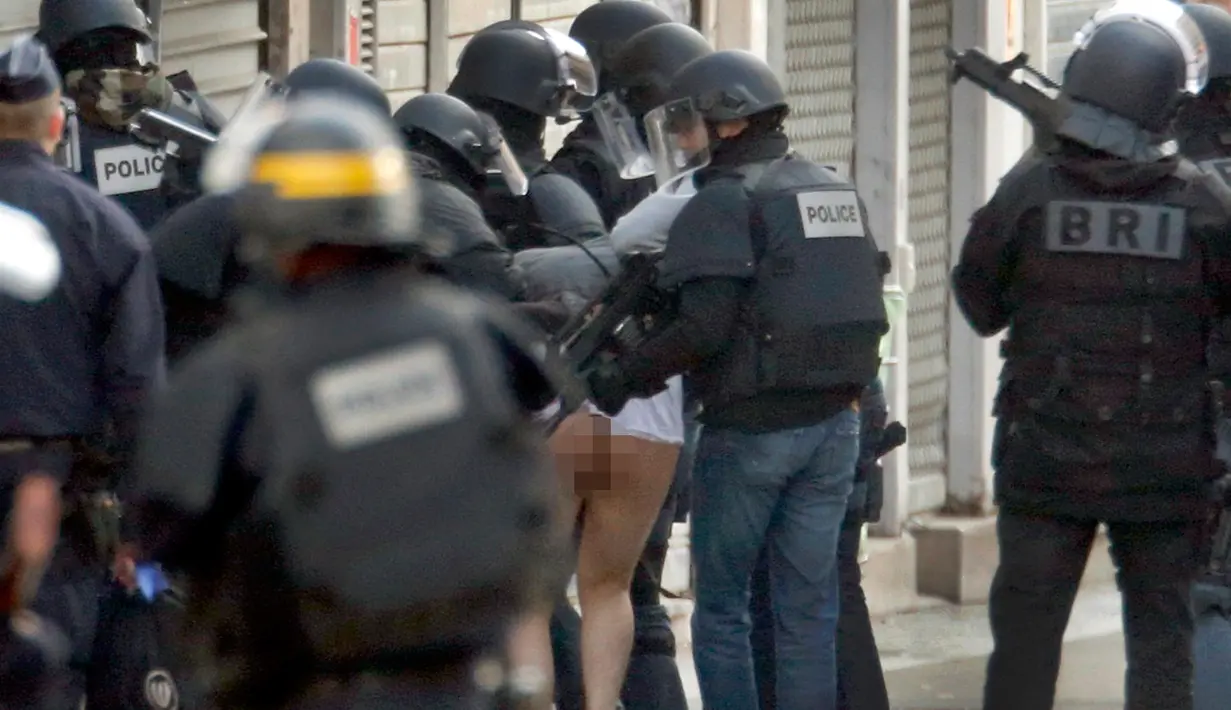 Seorang pria ditangkap oleh petugas keamanan Perancis selama operasi di Saint - Denis, Paris, Perancis, Rabu (18/11/2015). Petugas menangkap buronan atas peristiwa penyerangan pada Jumat malam di Paris lalu.  (REUTERS/Christian Hartmann)