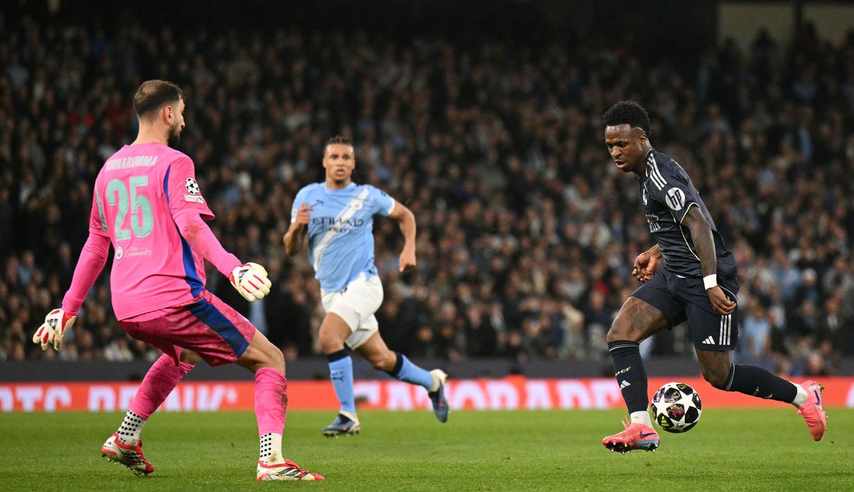 Vinicius Jr kembali mencatatkan namanya di papan skor saat penghujung pertandingan. Ia sukses mengkonversi umpan silang tajam Aurélien Tchouaméni menjadi gol pada menit ke-90+3. (AFP/Oli Scarff)