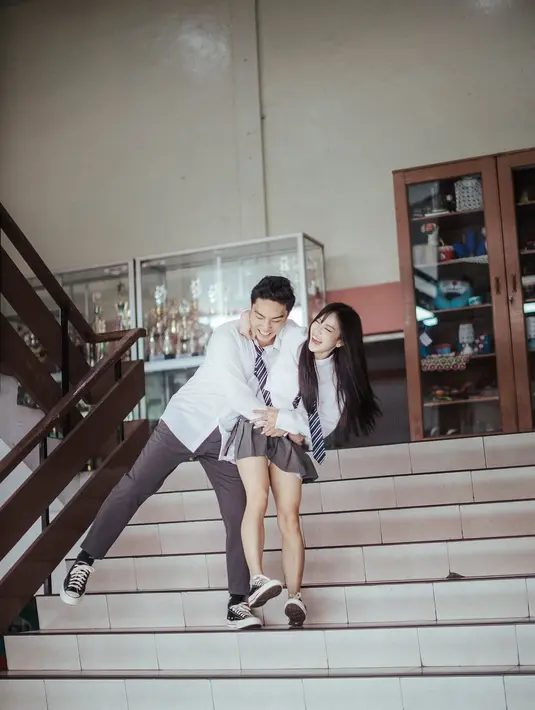 Sementara itu, Erwin Phang tampil dengan gaya maskulin dalam kemeja putih yang sedikit digulung pada bagian lengan, dasi bermotif garis, serta celana panjang abu-abu yang rapi.  [@flawlesspic].