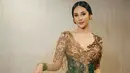 <p>Menggunakan kebaya nuansa coklat hijau, Anya terlihat anggun. Dengan tambahan rok batik bercorak sangat cocok dengan kebaya yang dikenakannya. [Instagram/anyageraldine]</p>