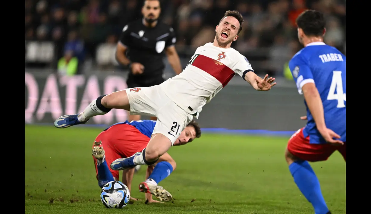 Striker Timnas Portugal, Diogo Jota mengerang kesakitan setelah ditekel gelandang Liechtenstein, Simon Luchinger pada laga lanjutan Grup J Kualifikasi Euro 2024 di Rheinpark Stadium, Vaduz, Jumat (17/11/2023) dini hari WIB. (AFP/Sebastien Bozon)
