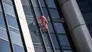 Alain Robert, pendaki bangunan pencakar langit asal Prancis memanjat Menara Montparnasse di Paris, Prancis, Rabu (12/10/2022). Alain Robert yang dikenal sebagai Spiderman Prancis itu kembali beraksi dengan memanjat Menara Montparnasse yang memiliki ketinggian 210 meter. (Bertrand GUAY/AFP)