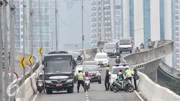 Petugas Kepolisan melakukan penindakan kepada pengedara motor yang memasuki JLNT Kampung Melayu - Tanah Abang di Jakarta, Senin (31/10). Karena kondisi angin diatas jembatan kencang dapat membahayakan pengendara sepeda motor. (Liputan6.com/Yoppy Renato)