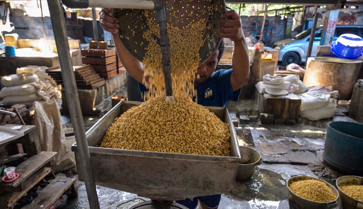 Fluktuasi harga kedelai yang terlalu cepat menyulitkan perajin dalam mengatur produksi dan berpotensi memicu keluhan konsumen. Tampak dalam foto, seorang pekerja membilas kedelai di pabrik tahu, Surabaya, Jawa Timur pada Kamis 5 Februari 2026. (JUNI KRISWANTO/AFP)