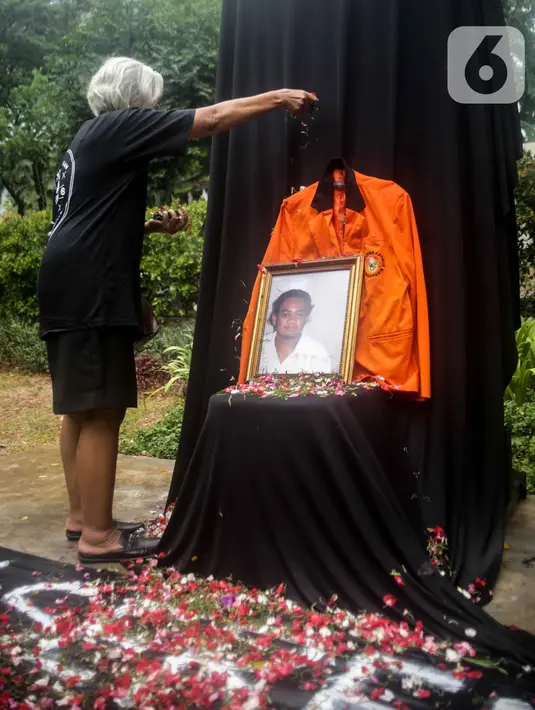 Sumarsih melakukan tabur bunga pada foto anaknya, Bernardus Realino Norma Wirawan atau Wawan yang tewas dalam tragedi Semanggi Satu selama peringatan 21 Tahun tragedi tersebut di halaman Universitas Atma Jaya, Jakarta, Rabu (13/11/2019). (Liputan6.com/Faizal Fanani)