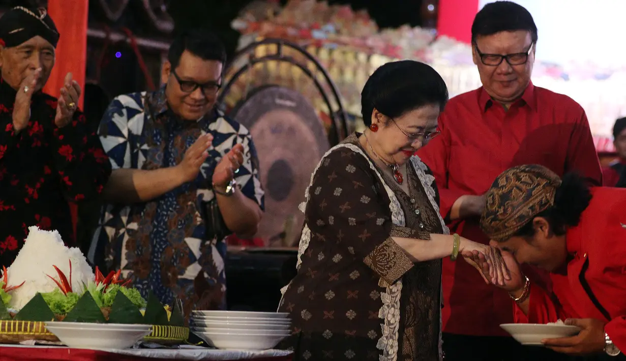 Ketua Umum PDIP Megawati Soekarnoputri menerima cium tangan dari dalang sekaligus membuka pagelaran wayang kulit seusai memberikan potongan tumpeng dalam rangkaian HUT PDIP ke-45 di Tugu Proklamasi, Jakarta, Sabtu Malam (27/1). (Liputan6.com/Johan Tallo)